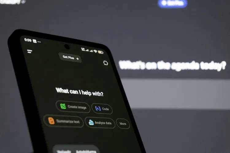 ChatGPT on a phone and desktop in the background